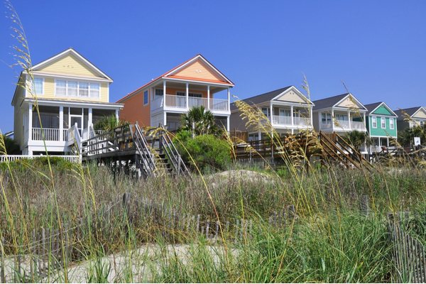 colorful beach rental houses with stairs down to the dunes