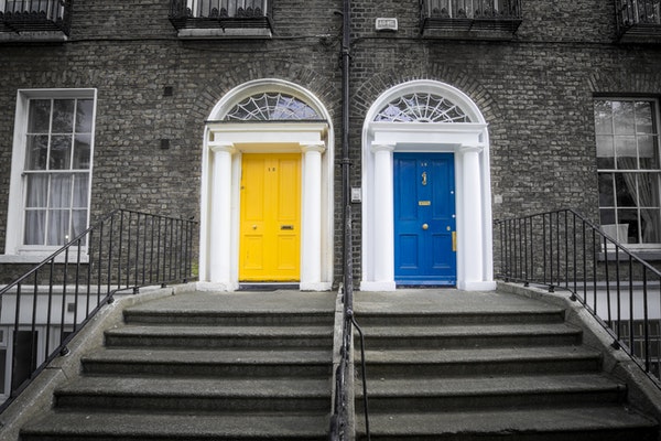 brick building with 1 blue and 1 yellow door next to each other