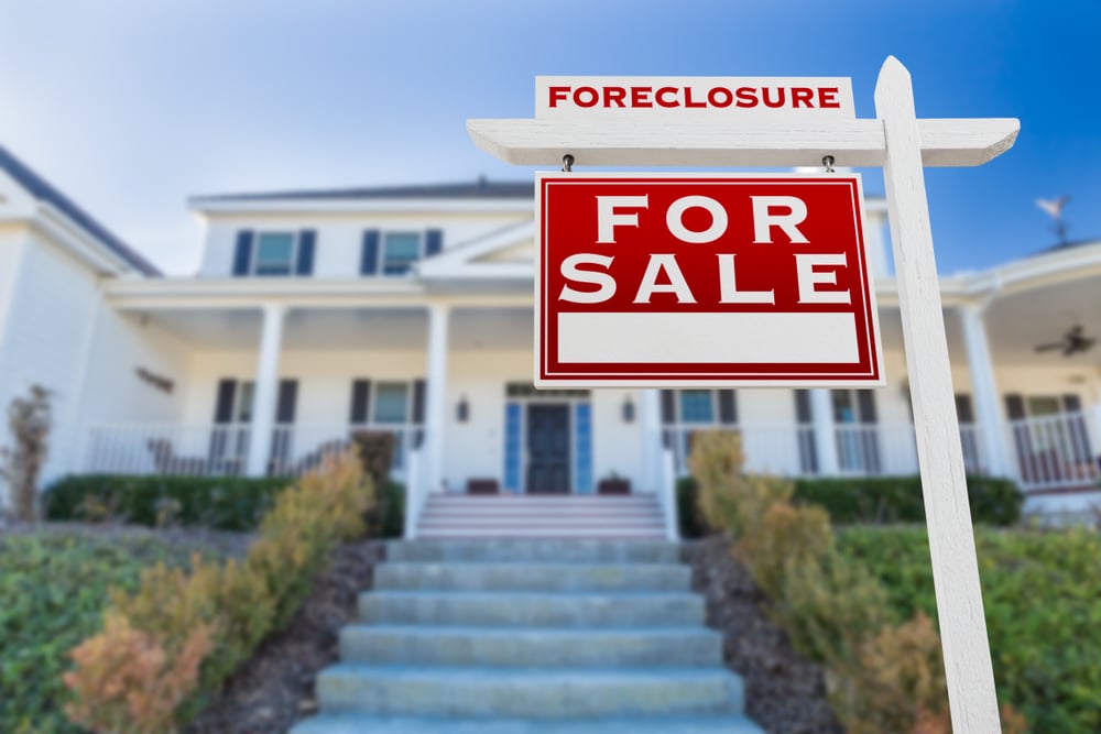 white house with foreclosure sign